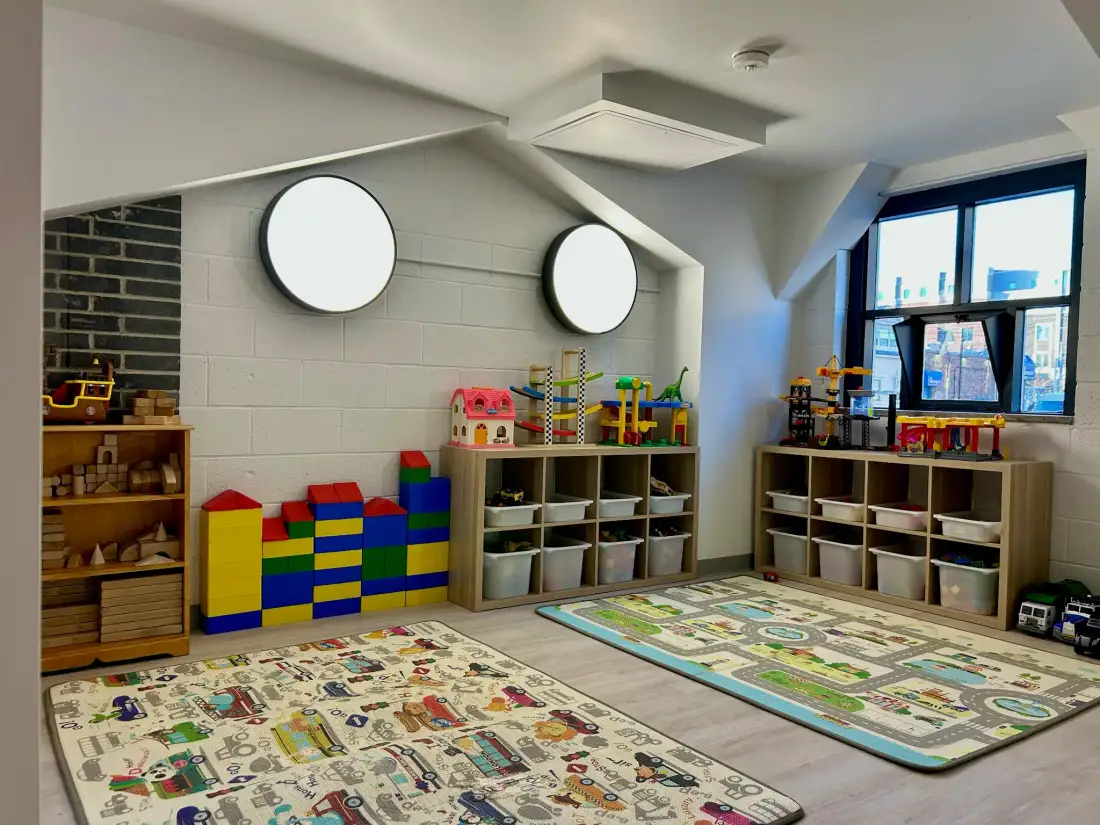 Play area inside house nook with porthole windows and colorful toys