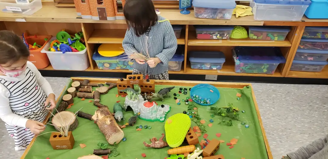 Children playing with a dinosaur small world setup