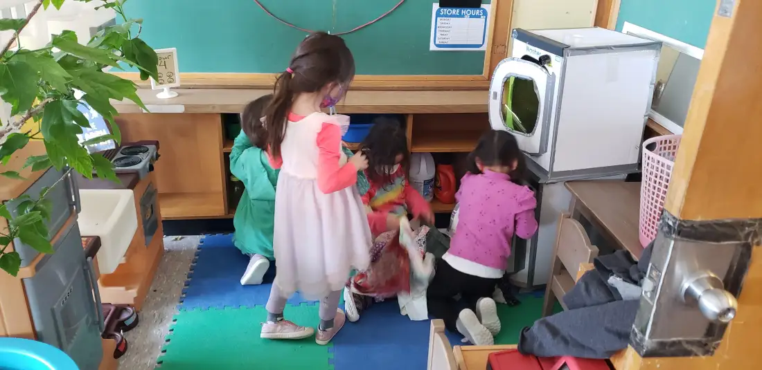 Children in dramatic play pretend kitchen