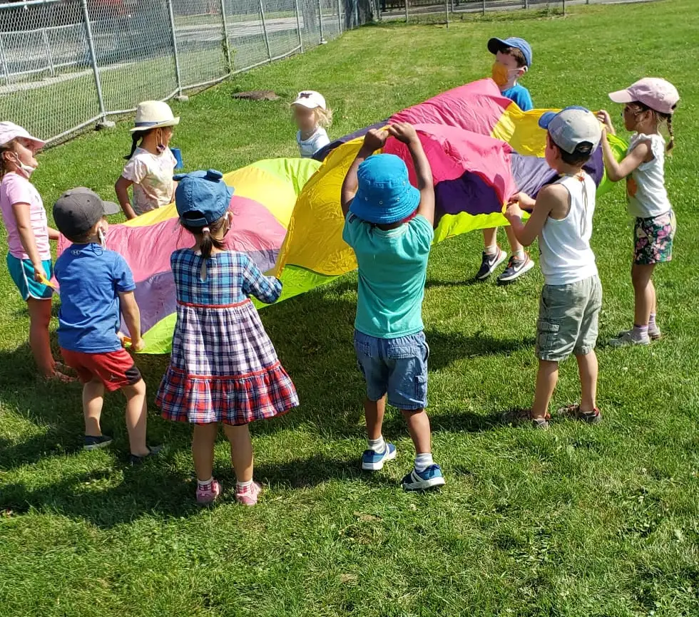 Children playing a parachute game on an outdoor field